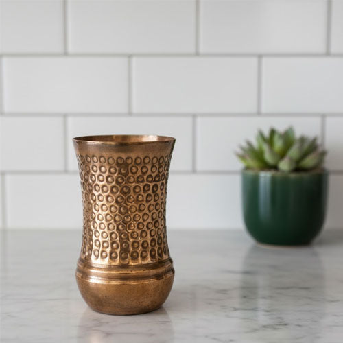 A beautiful, tall copper tumbler featuring an intricate hammered pattern